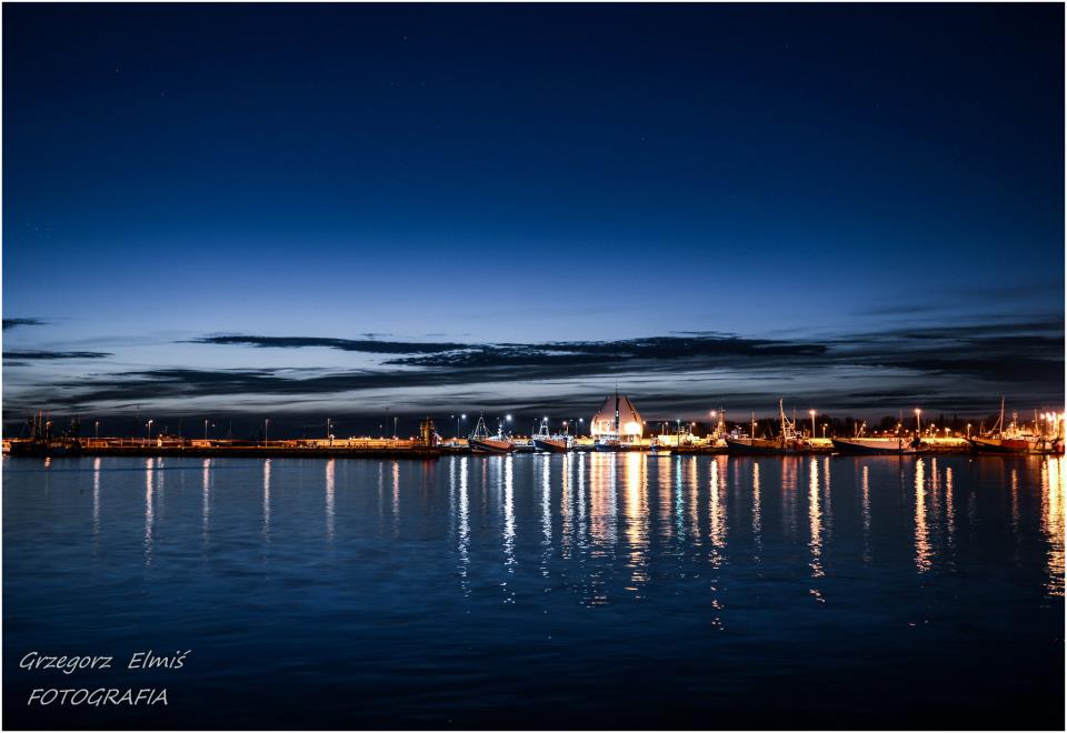 Obraz przedstawia nocną panoramę Portu Rybackiego w Helu